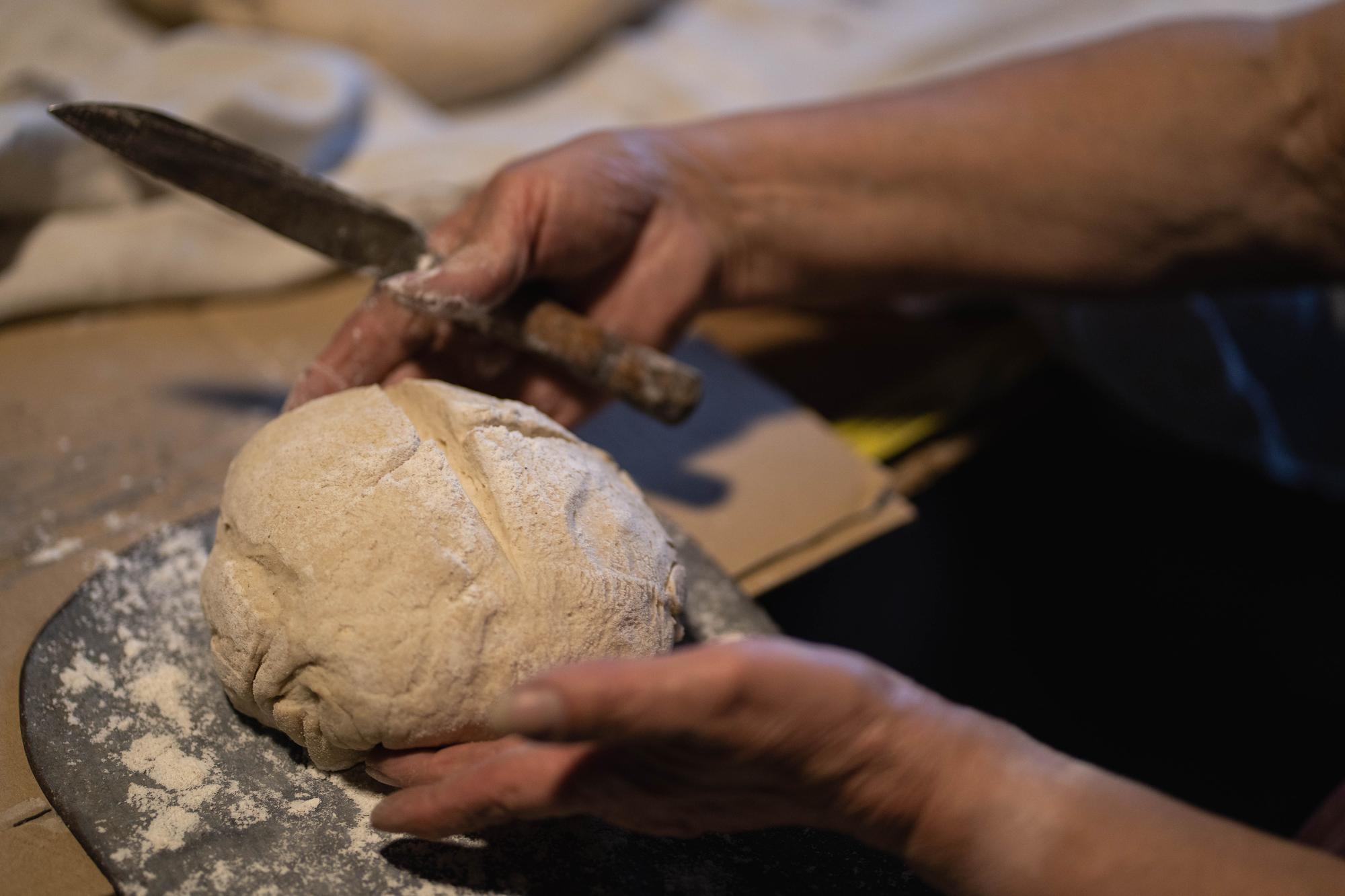Mani che impastano pane artigianale
